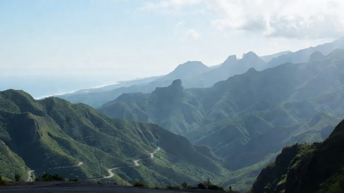 The winding highway descending through the green Sierra Madre del Sur toward the distant Pacific coast on the Oaxaca City–Puerto Escondido route